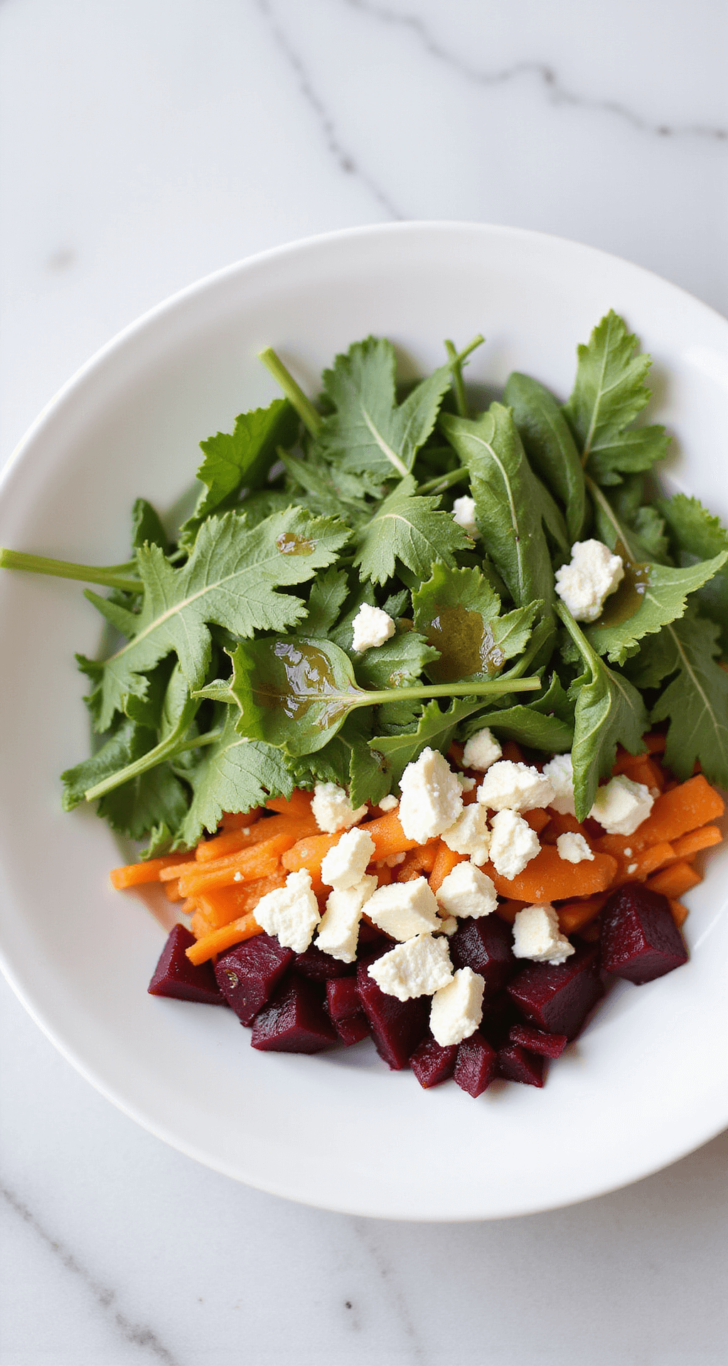 Artistiek gepresenteerde detoxsalade in een witte keramische kom op een lichte marmeren aanrecht. Geraspte biet en wortel vormen een kleurrijke basis, bedekt met verse rucola en verkruimelde feta. Honing-olijfolie dressing glinstert bovenop, gegarneerd met extra rucola en feta.